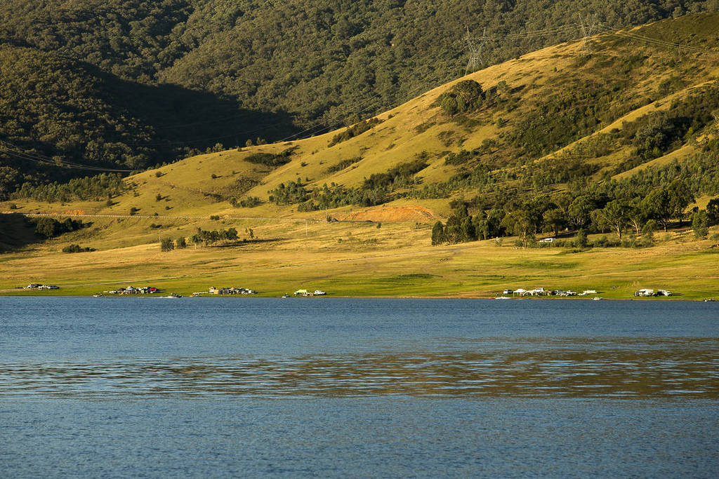 Camp sites along the edge of Blowering Dam near Tumut, NSW, with rolling green hills and calm blue water