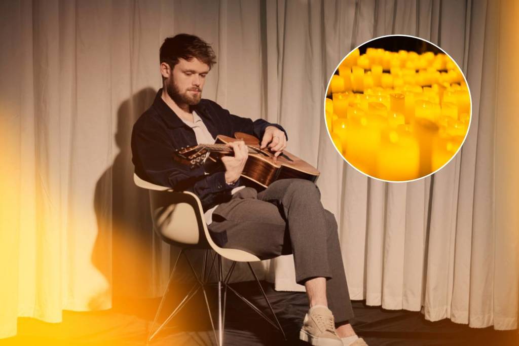 Platinum English singer-songwriter James TW posing in a seated position with his guitar