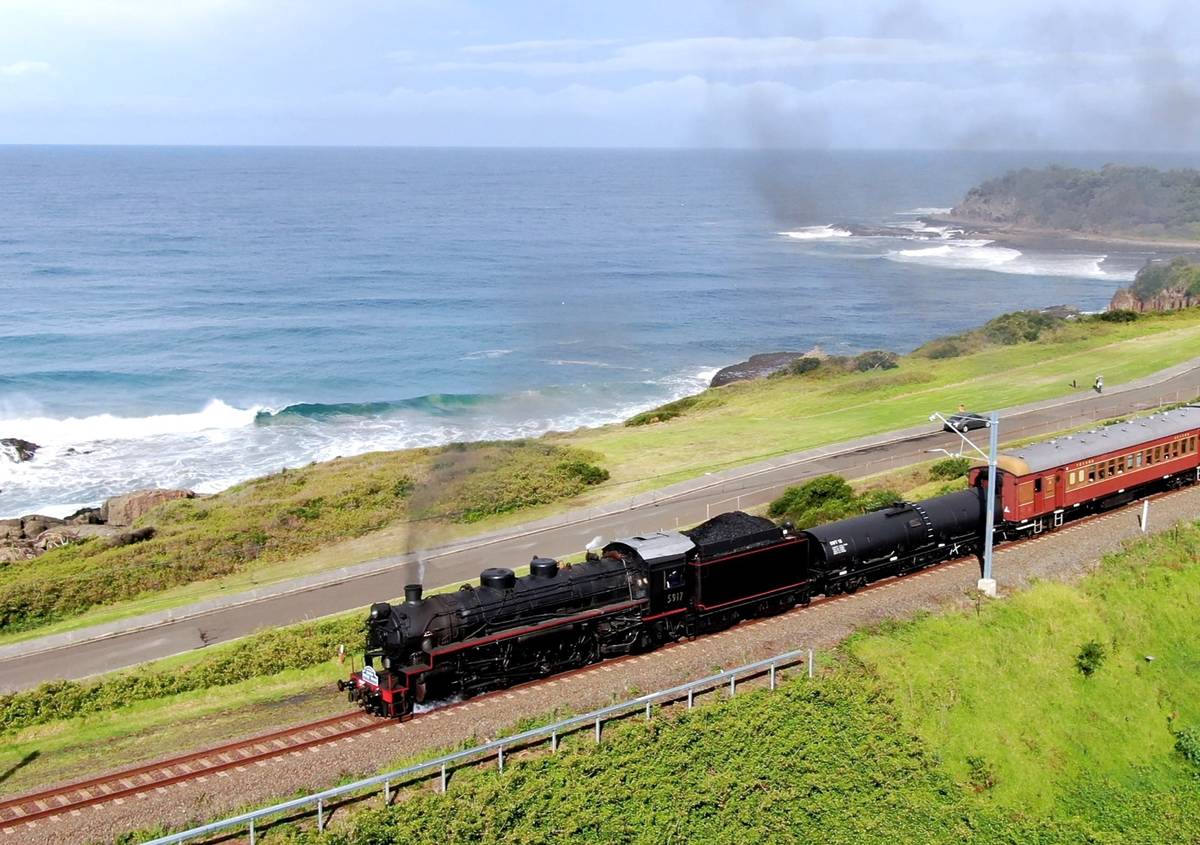 The Kiama Picnic Train travelling along the NSW South Coast with ocean views and green cliffs in the background