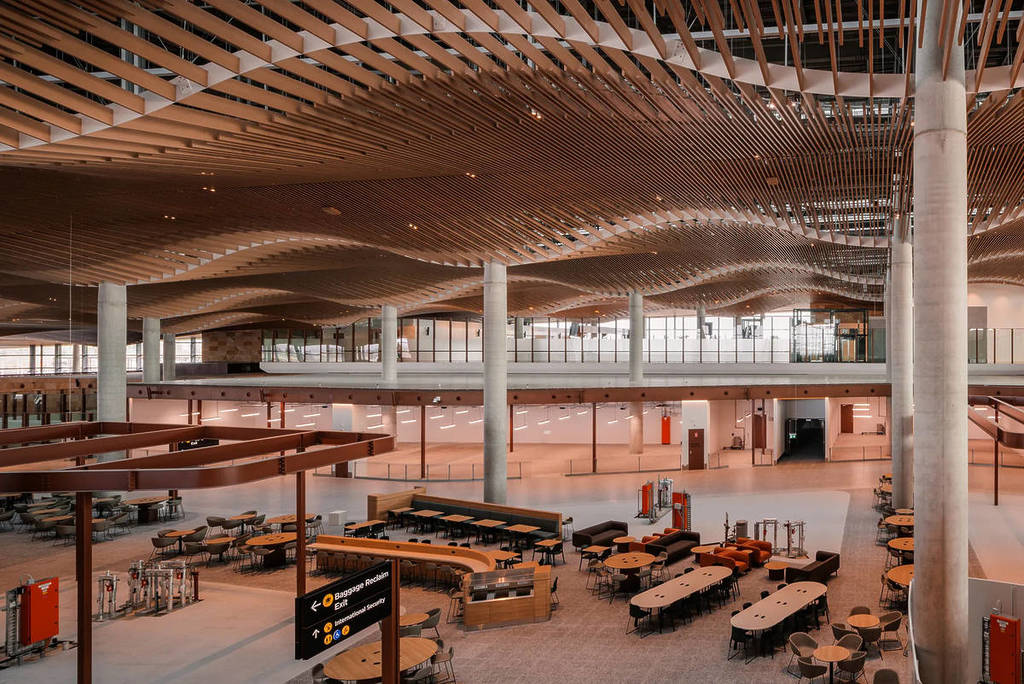 Interior of Western Sydney Airport with flowing timber ceiling and open seating area