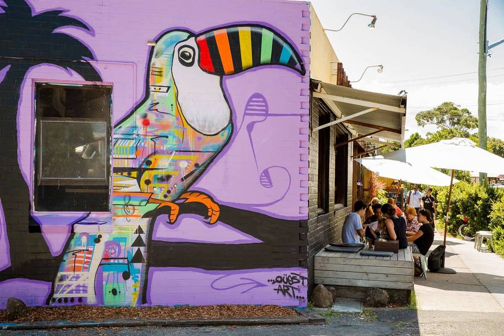 Colourful toucan mural next to an outdoor café in Byron Bay