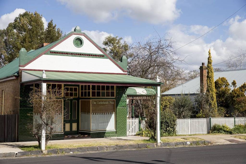 Historic building with green and white trim on Millthorpe's quiet main street, evoking winter charm
