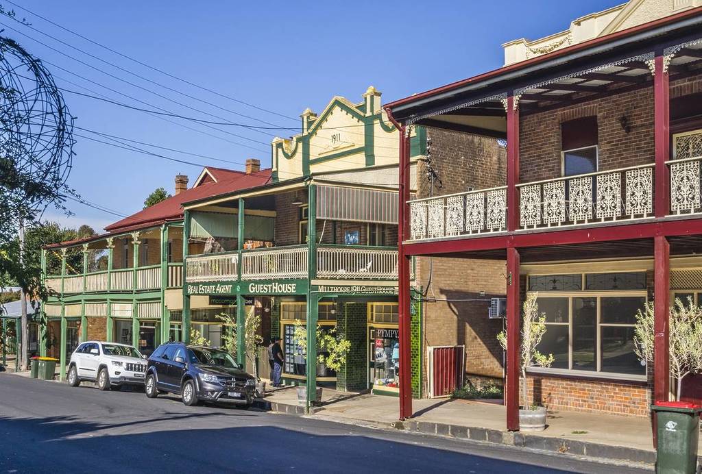 Historic terrace buildings along Millthorpe’s main street, including a guesthouse and shopfronts with Federation-style balconies and 1911 signage