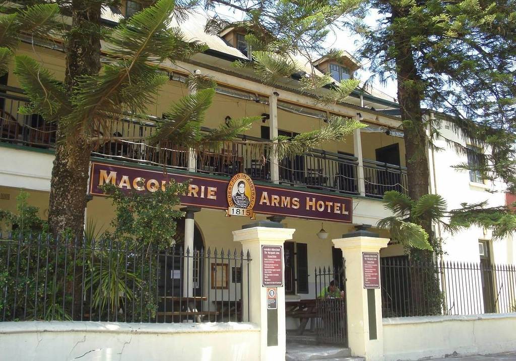 Front view of the Macquarie Arms Hotel in Windsor, showing its historic signage, upper balcony, and surrounding iron fence