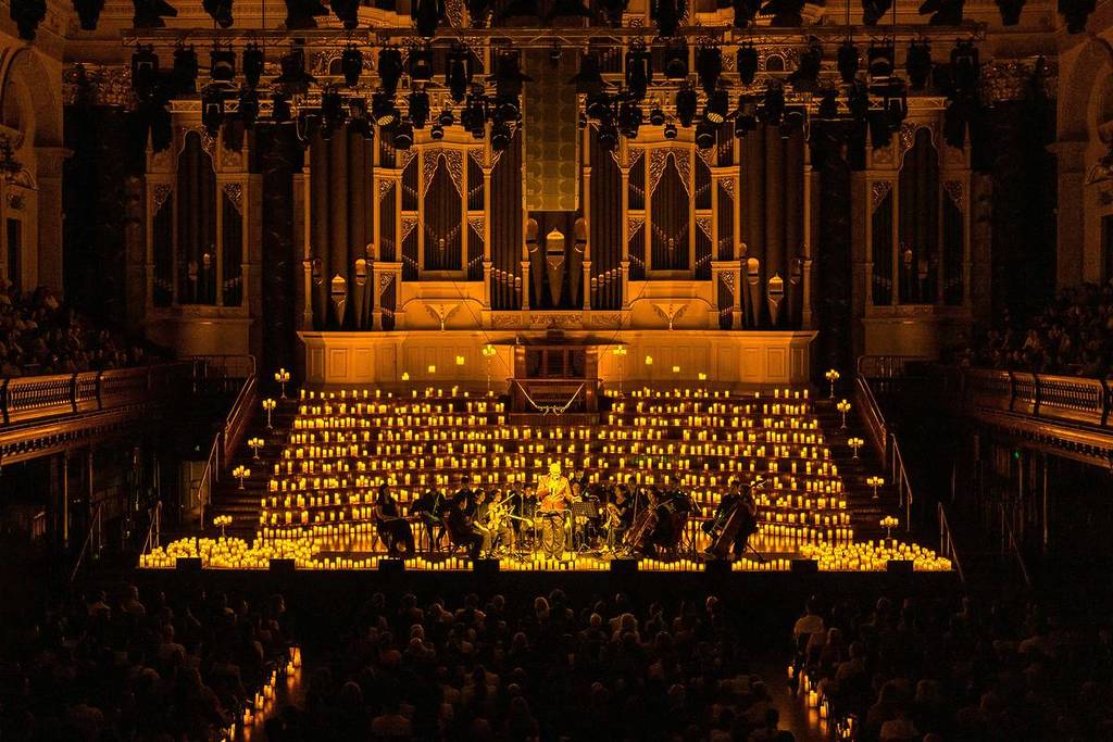 Sydney Town Hall, illuminated with golden lights as an orchestra plays.