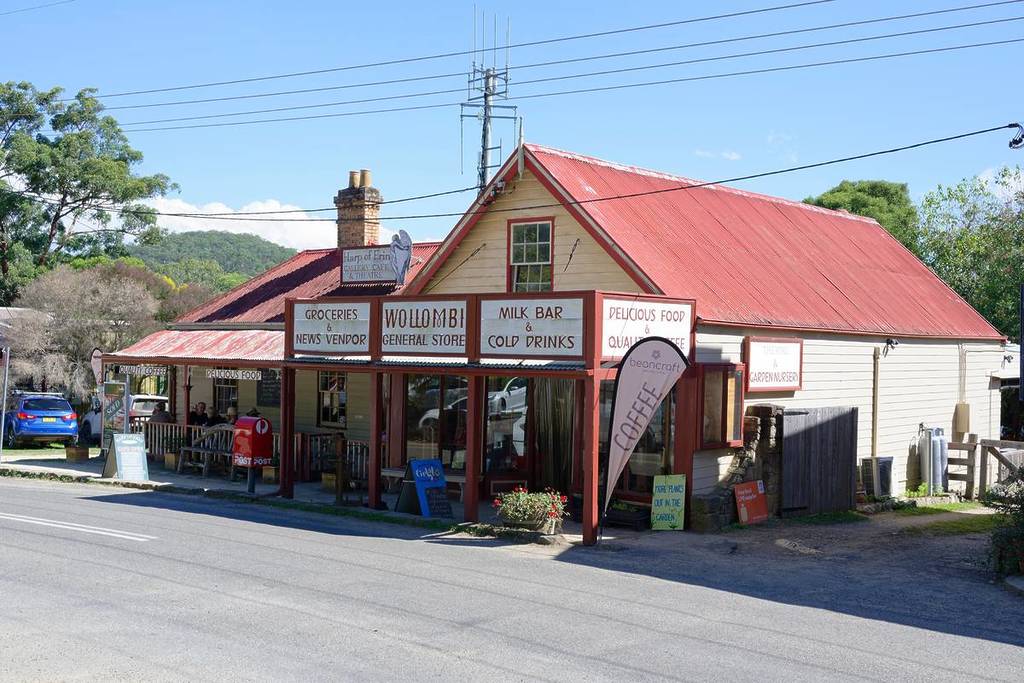 Wollombi General Store with a red roof, signage for groceries, milk bar, and coffee, located on a rural street