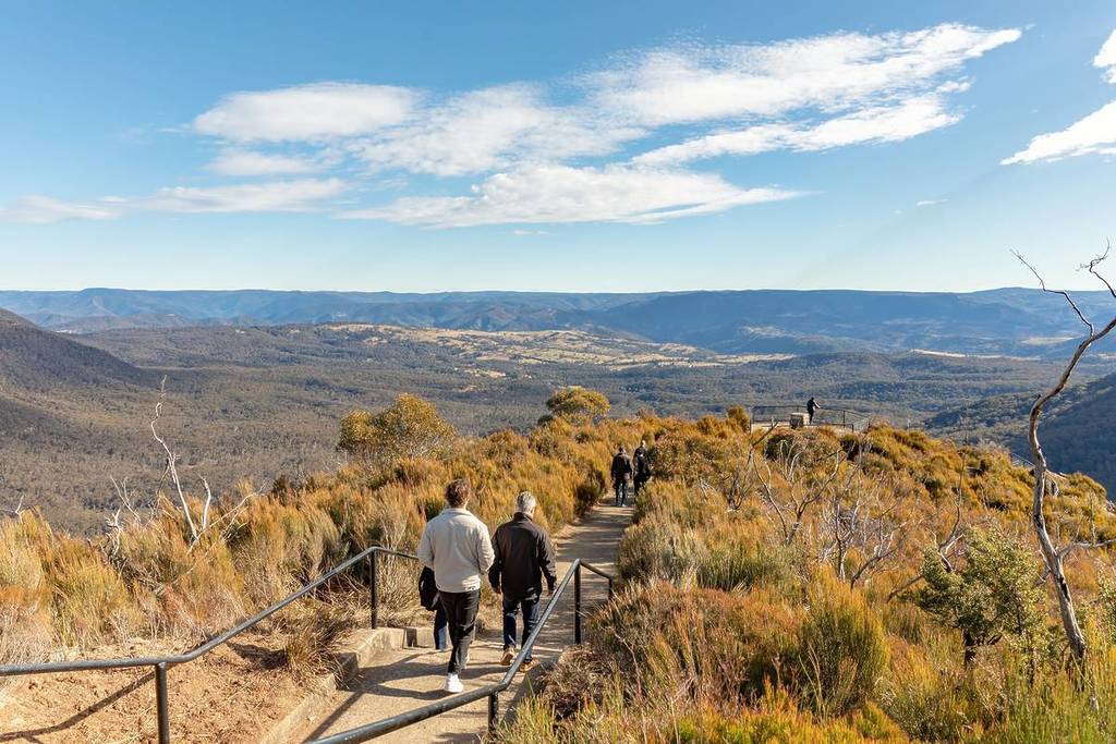 People walking along a scenic mountain trail towards Cahill Lookout in the Blue Mountains, in Katoomba