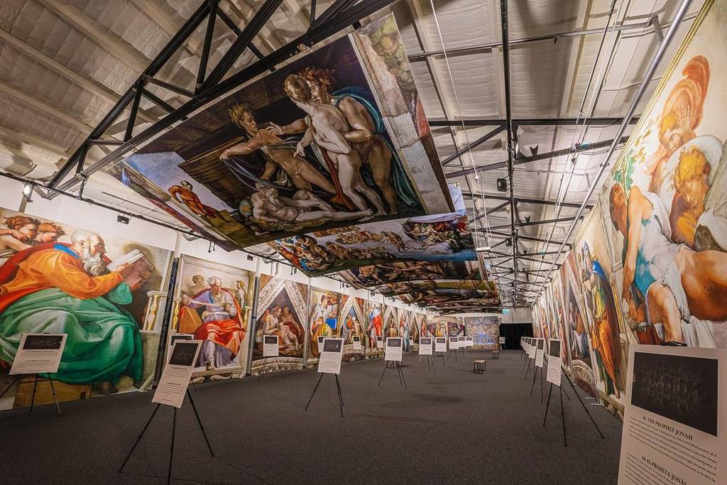 Michelangelo's frescoes line the walls and ceiling of a room at The Sistine Chapel Exhibition.