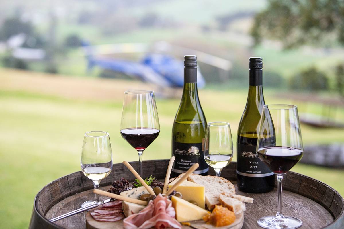 A bottle of Shiraz and Chardonnay, paired with a gourmet cheese and charcuterie platter at a winery in Gerringong