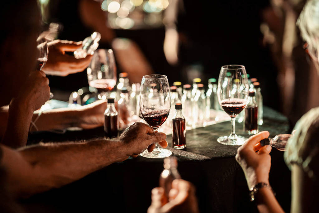 A close-up shot of wine glasses and little individual bottles of wine on a table.