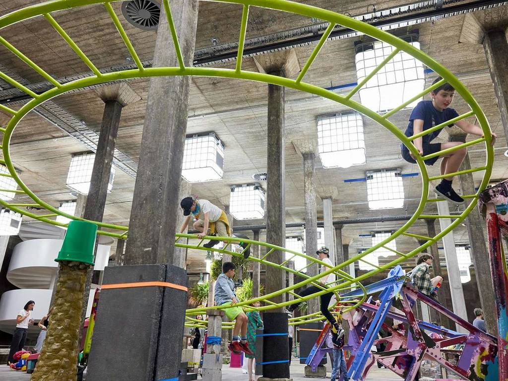 Children climbing a bright green play structure inside the Tank at the Art Gallery of NSW during Mike Hewson’s interactive exhibition The Key’s Under the Mat