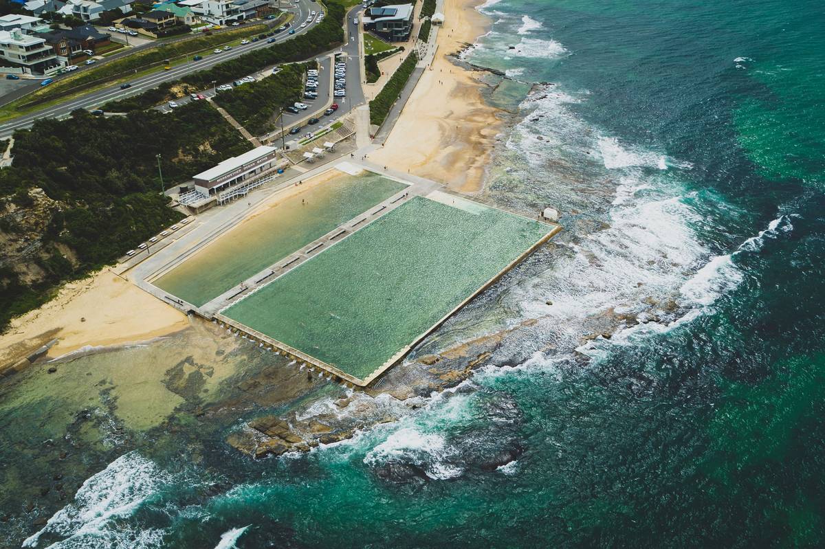 Aerial photo of Merewether Ocean Baths and the surrounding coastline, with turquoise water filling the pool