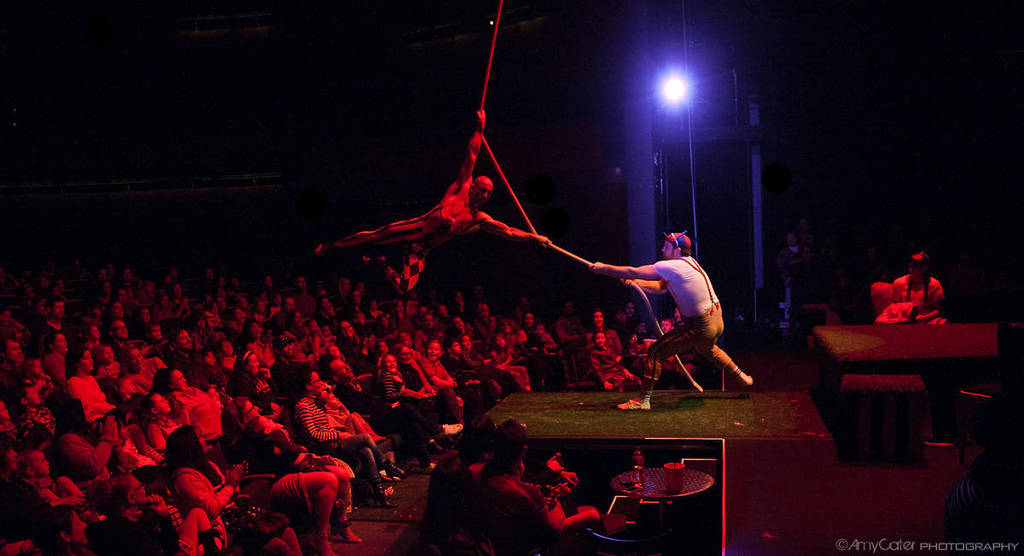 A performer swings out on a rope over the crowd at The Mad Hatter's Tea Party.