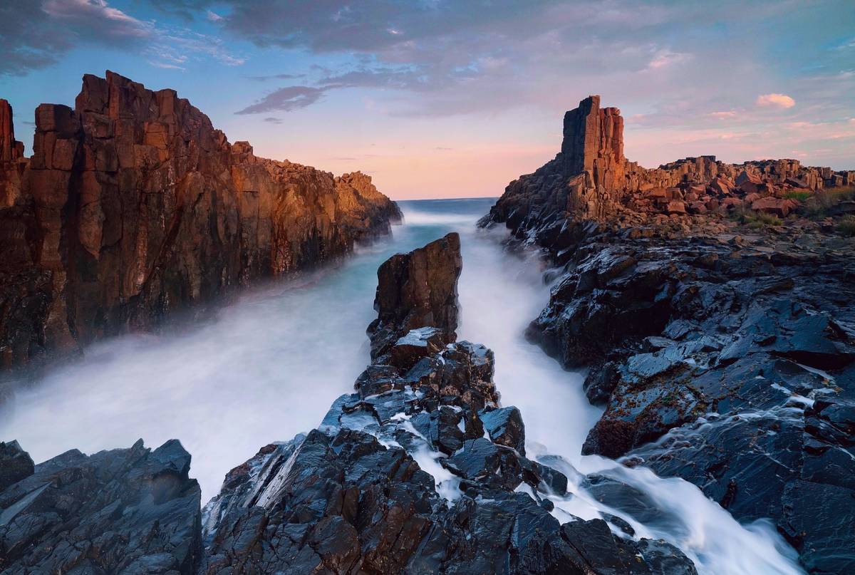 Cathedral Rocks in Kiama, NSW, with waves crashing between rugged basalt cliffs at sunrise