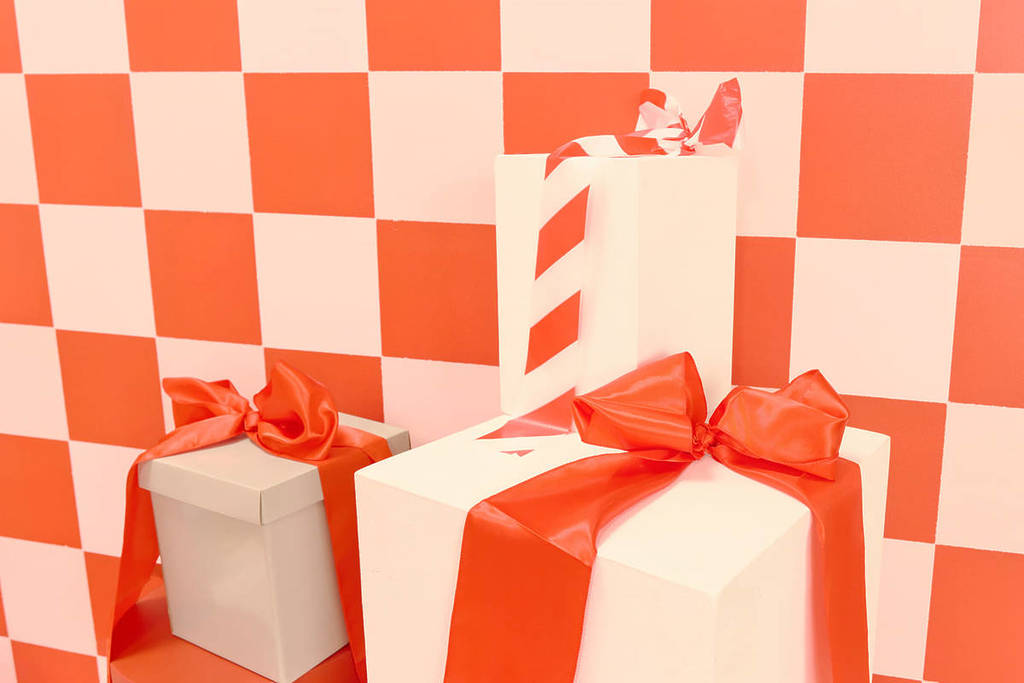 A close up shot of presents in white boxes with red ribbon at Santa's Enchanted Photo Workshop.