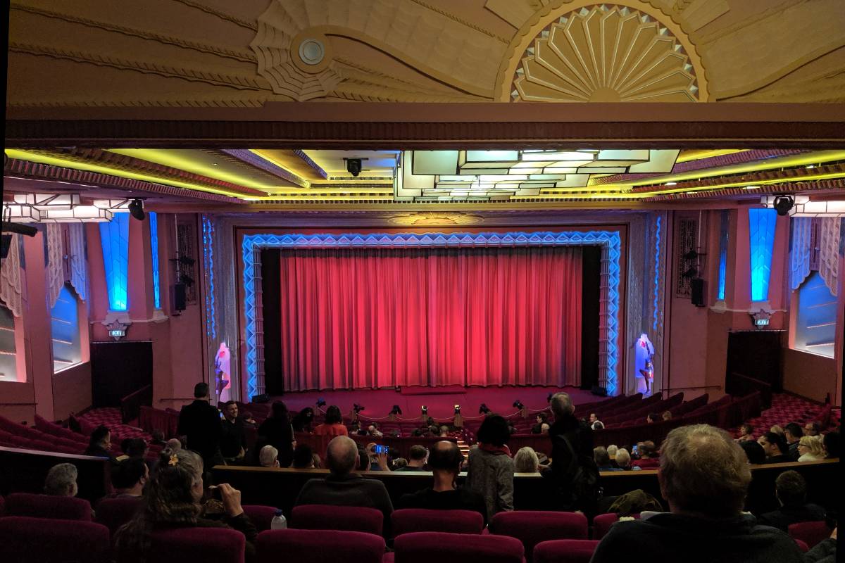One of the screens with a red curtain, Art Deco features and red velvet seats at Hayden Orpheum Picture Palace