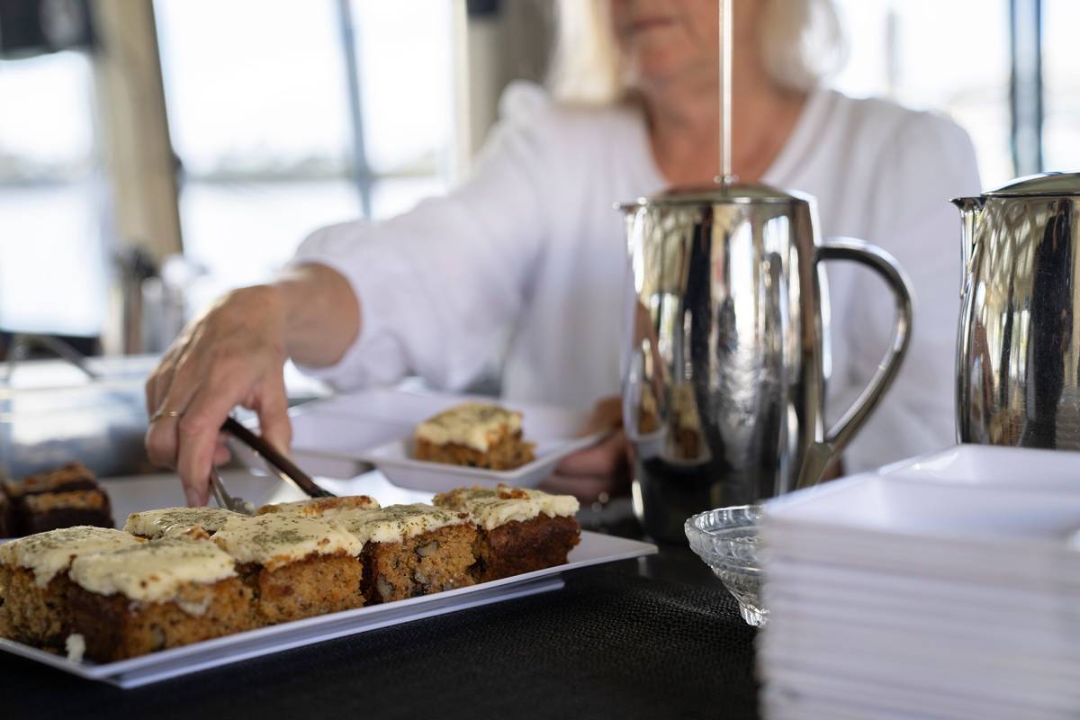 Slices of iced cake served on a table inside a Brunswick Heads cafe with river views in the background