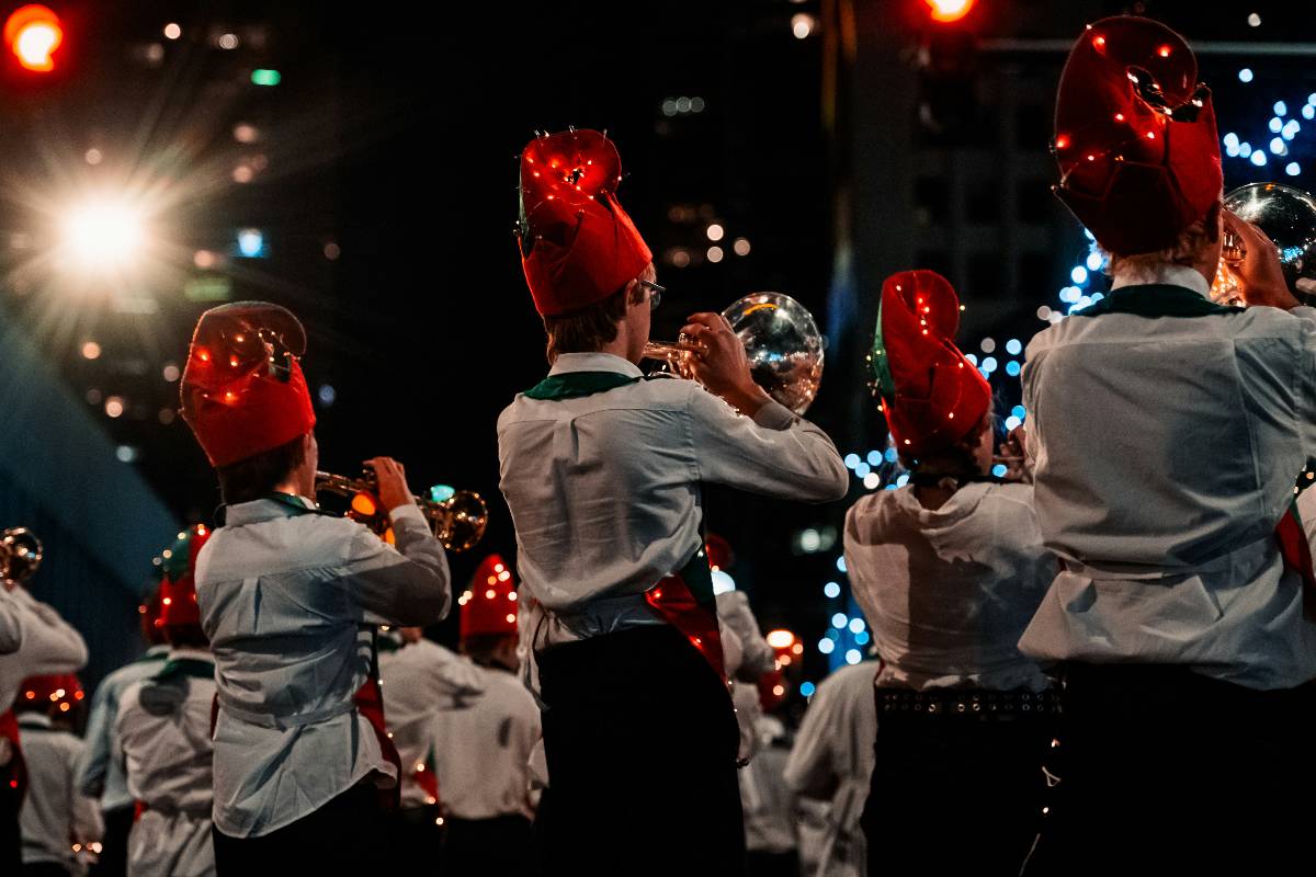 A Christmas marching band performing on the street with trumpets
