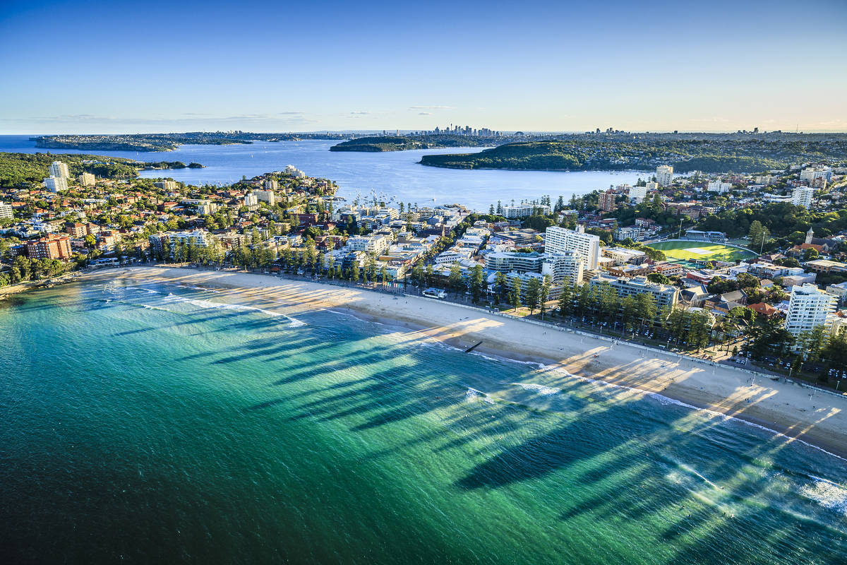 An aerial view of Manly Beach, the shoreline, and the surrounding suburb