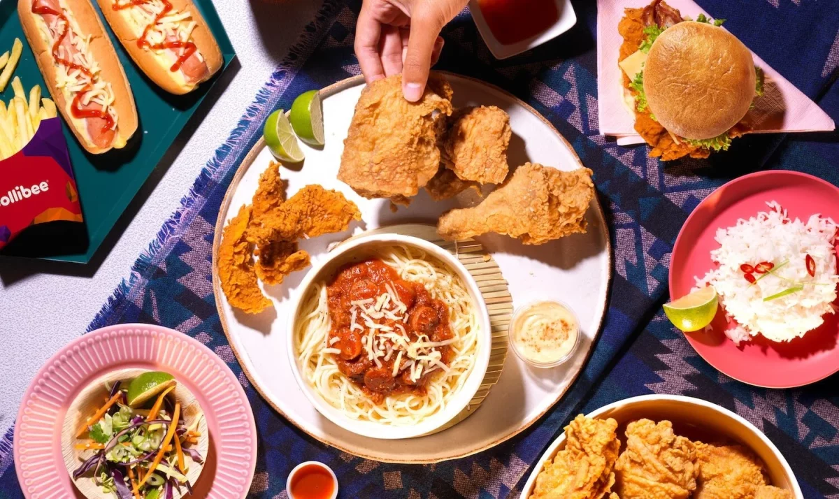 Jollibee fried chicken and spaghetti served alongside rice, burgers and sides on a table