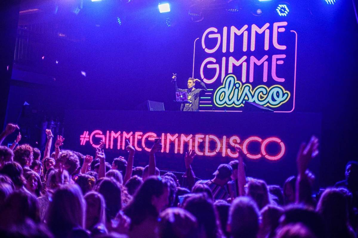 A DJ spinning songs at Gimme Gimme Disco dance party