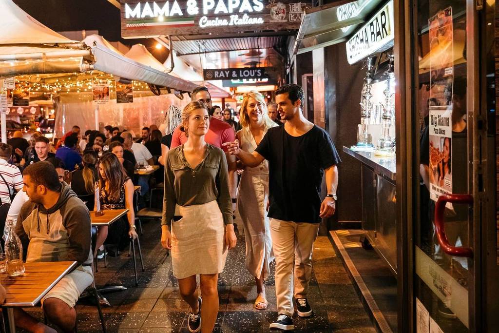 Busy night-time dining scene in Parramatta with people walking past packed restaurants and bars