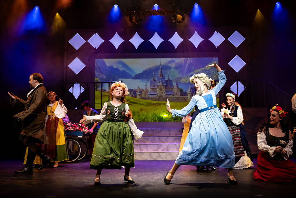 Anna and Elsa dance on stage at Frozen: The Musical.