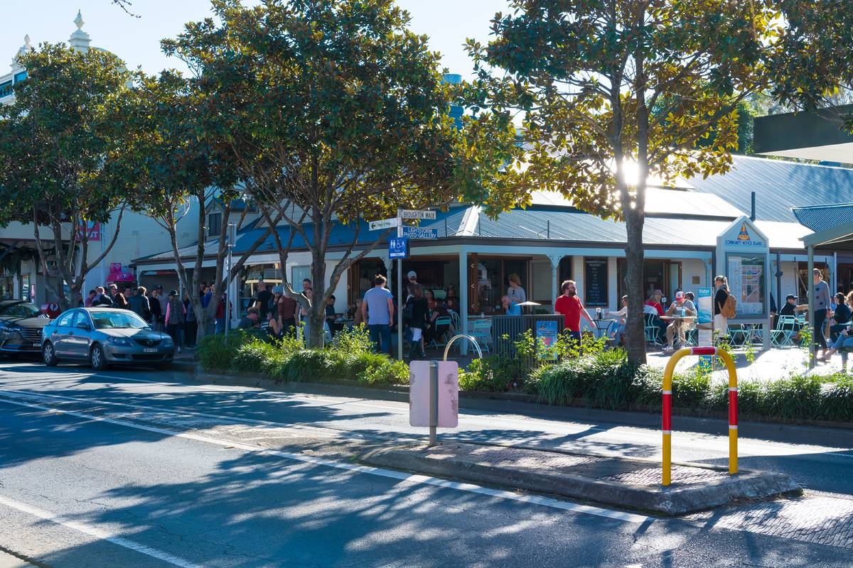 Berry main street showing busy cafes, pedestrians and outdoor seating on a sunny day