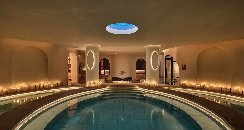Indoor circular bathhouse pool at Saint Haven North Sydney surrounded by candles, curved walls and soft ambient lighting