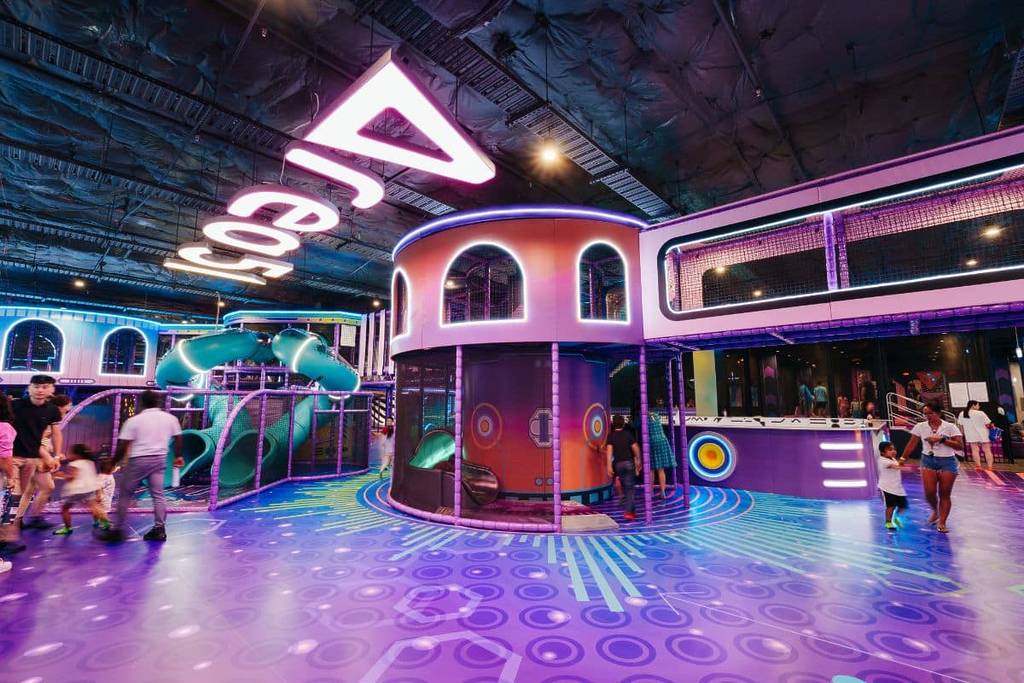 Large multi-level indoor playground at Area 51 Castle Hill with giant slides, climbing zones and bright neon lighting