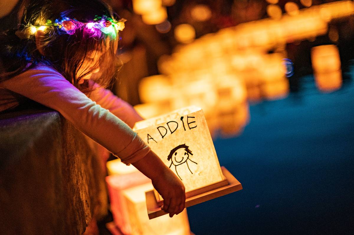 Child holding a personalised water lantern before release at a water lantern festival