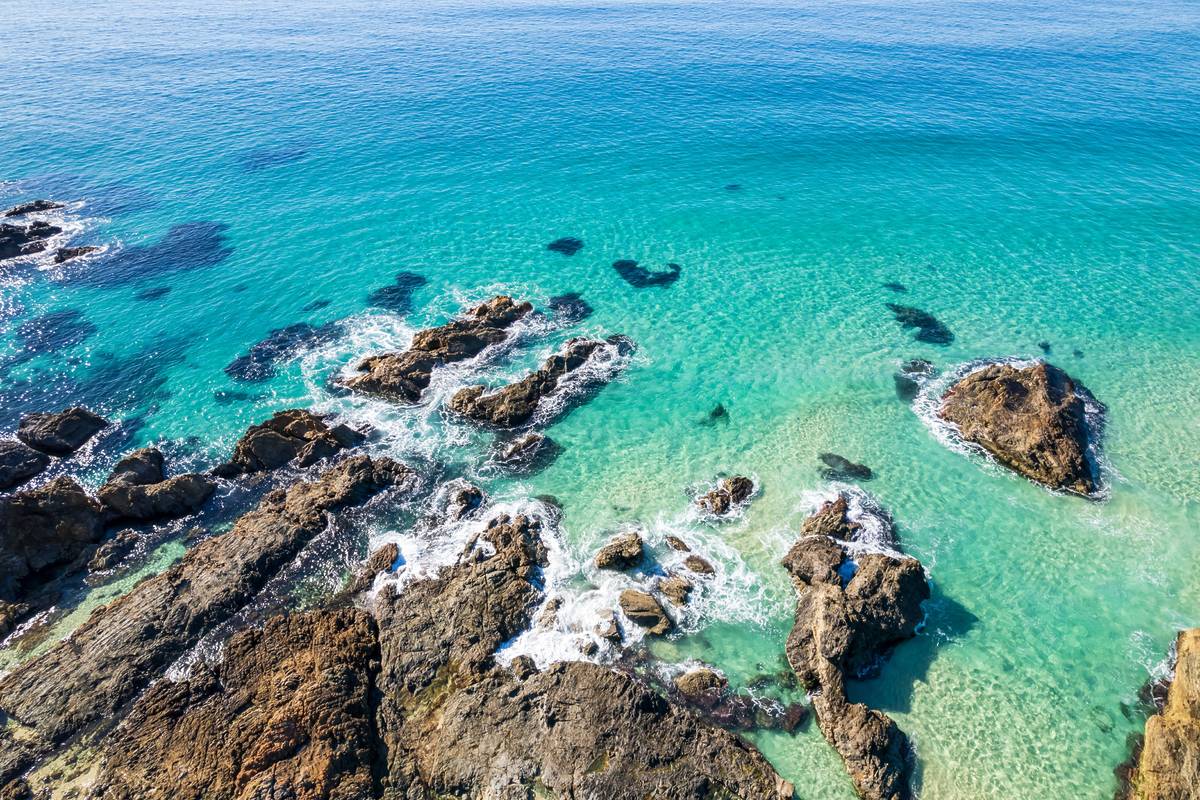Turquoise ocean with rocky outcrops and crystal-clear water along the NSW coast