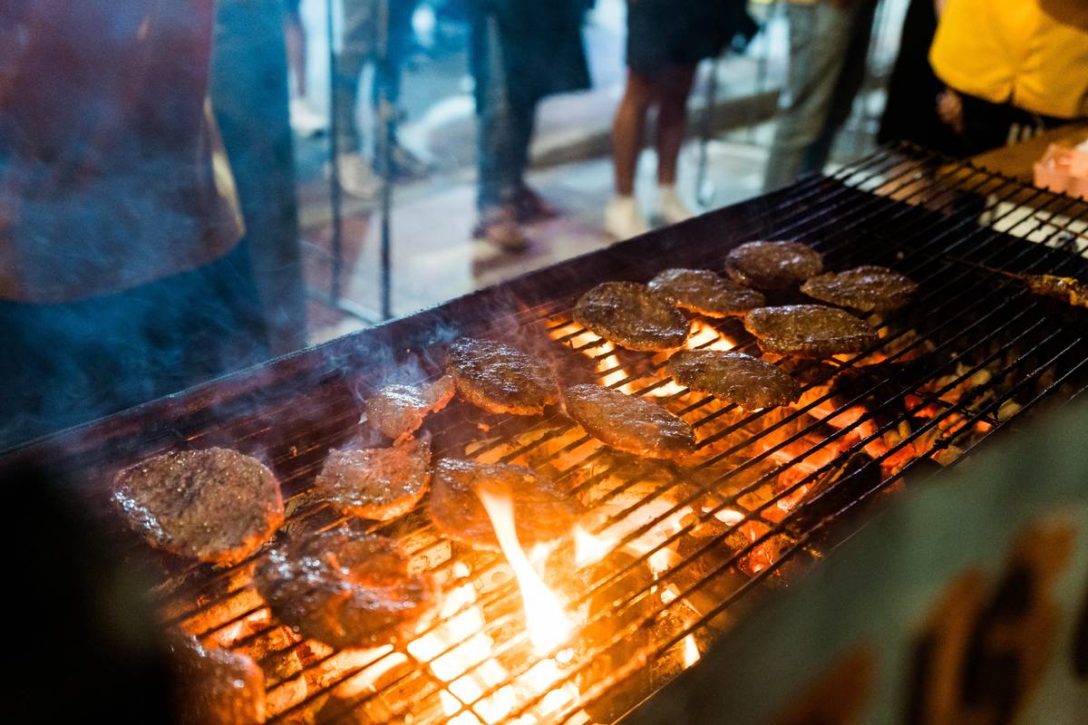 Burgers cooking over open flames at a food stall during Lakemba Nights Ramadan night market in Sydney