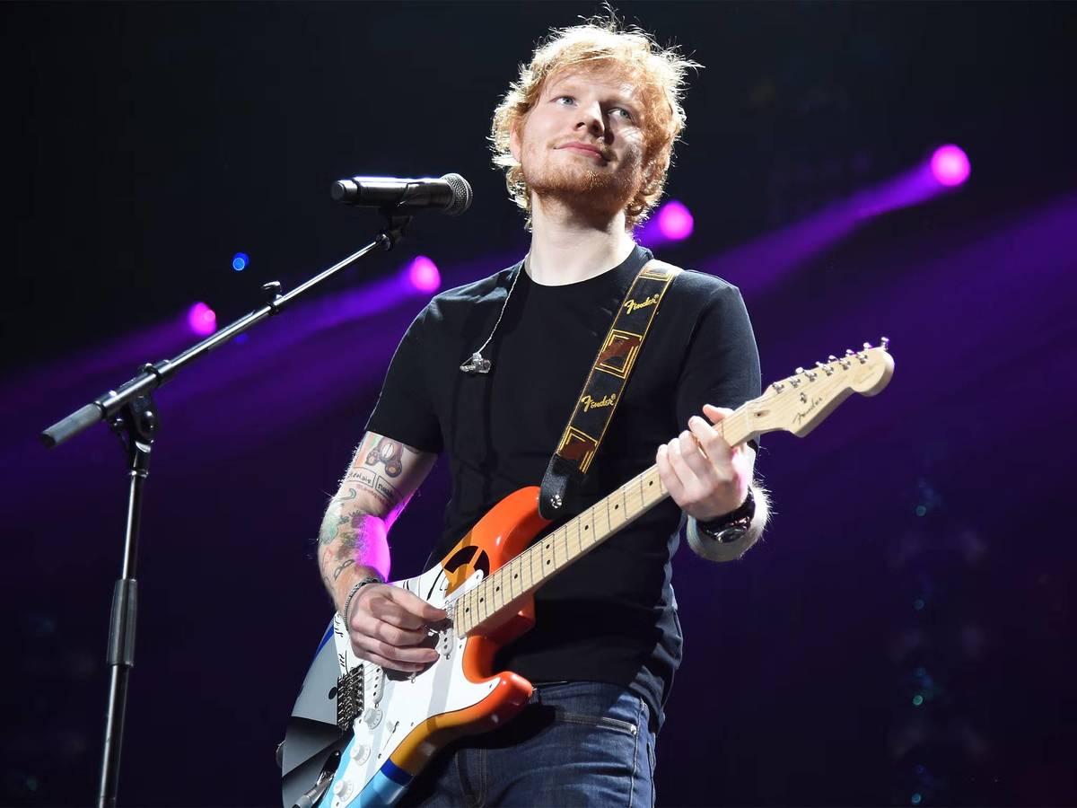Ed Sheeran performing live on stage with an electric guitar during his Loop Tour
