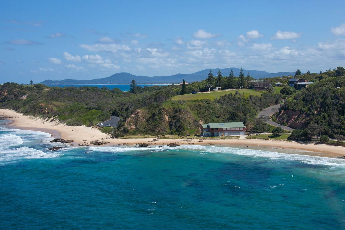 Coastal view of Nambucca Heads with sandy beaches, rolling waves and homes by the coast