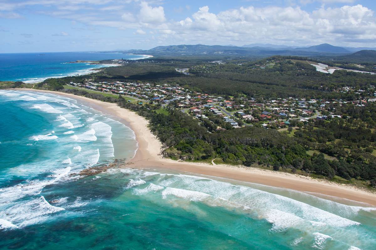 Aerial view of a long sandy beach and turquoise waves along the New South Wales coastline