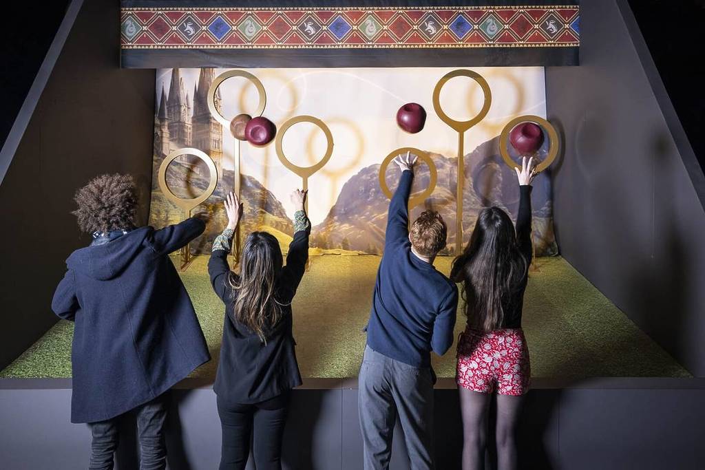 Four friends throw quaffles through Quidditch hoops at Harry Potter: The Exhibition.