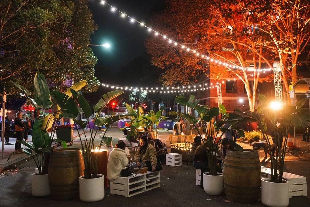 Visitors dining outdoors under string lights during a food event at Vivid Sydney in Barangaroo