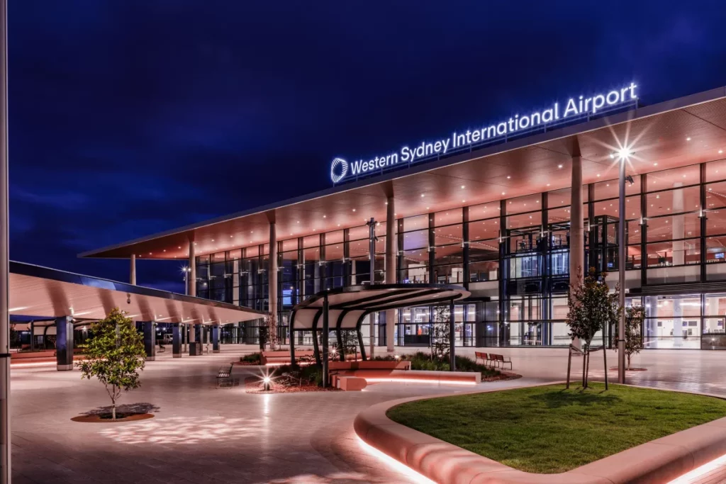 Western Sydney International Airport terminal at Badgerys Creek illuminated at night with the airport signage visible