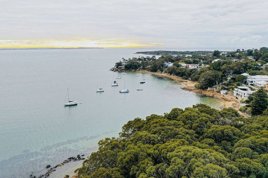 Aerial view of Bundeena village and Port Hacking surrounded by bushland near Royal National Park
