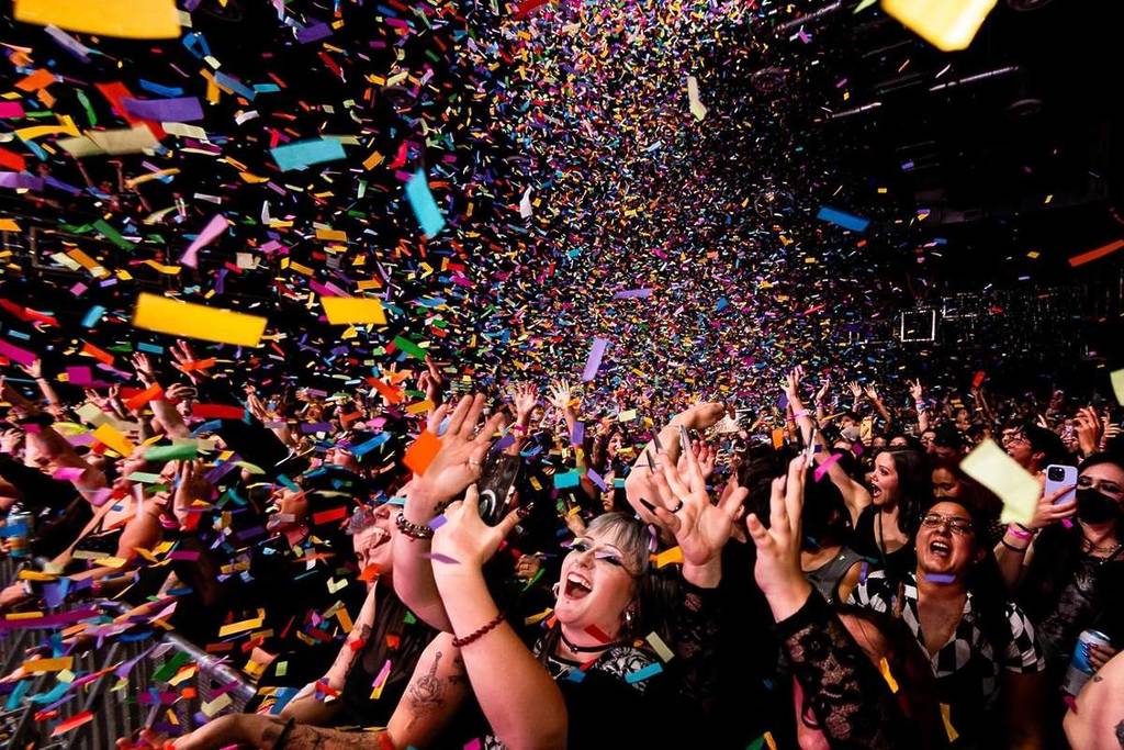 A crowd of people singing and dancing under confetti at Emo Night Brooklyn