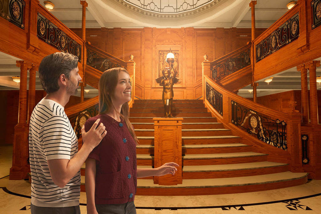 A man and woman explore the famous Grand Staircase aboard the Titanic.