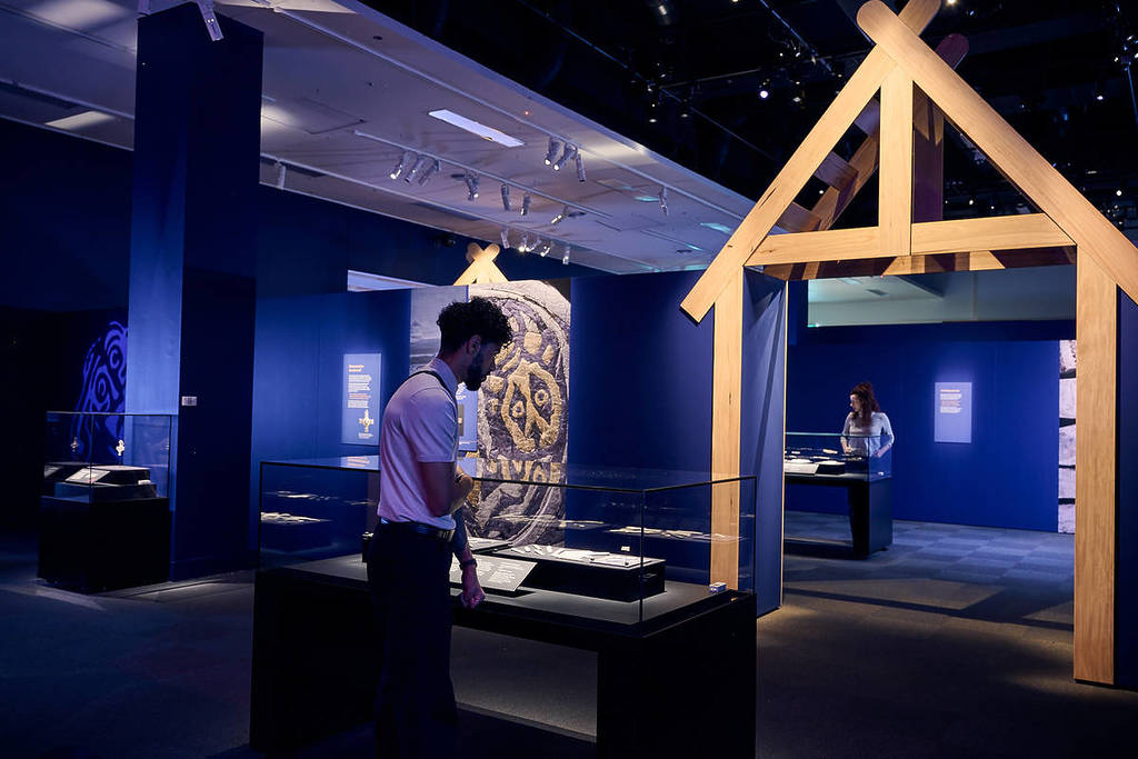 Visitors viewing Viking artefacts inside the Galloway Hoard exhibition at a museum gallery