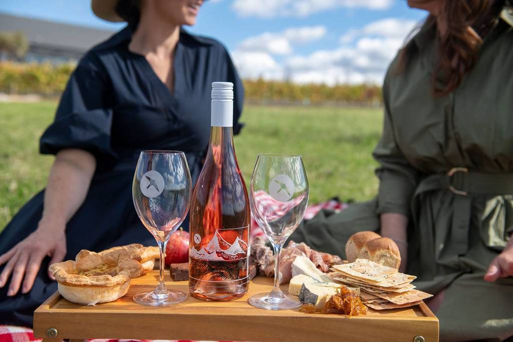 Wine tasting setup in Orange NSW vineyard with rose, cheese and picnic spread
