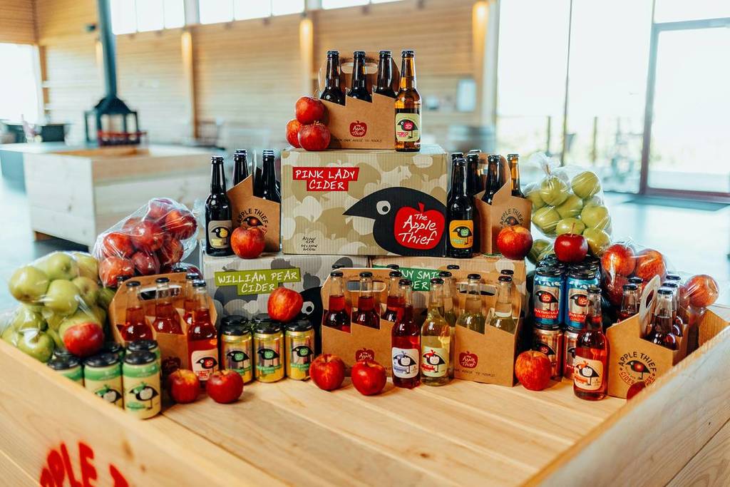 Apple cider bottles, fresh apples and local produce displayed inside The Apple Thief Cider House near Batlow, NSW