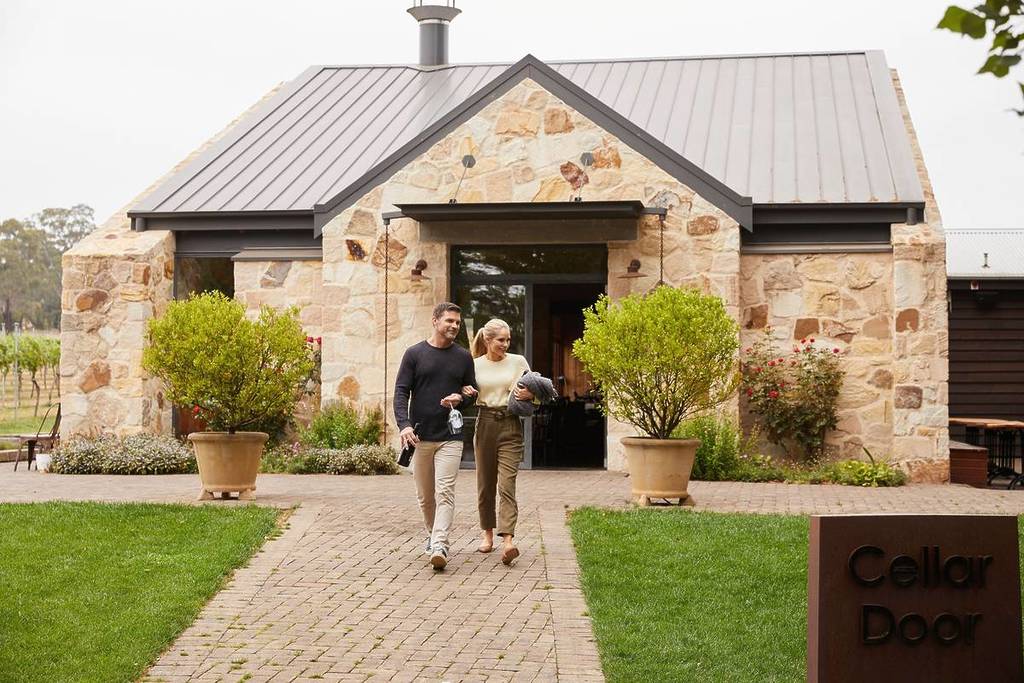 Couple walking past the cellar door at Bendooley Estate in the Southern Highlands