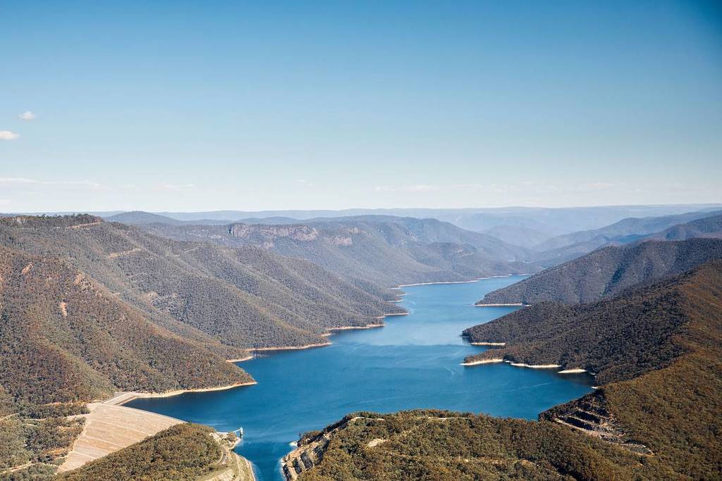 Aerial view of a winding blue reservoir surrounded by forested mountains near Tumut, NSW