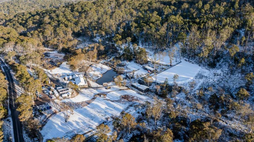Aerial view of Corin Forest blanketed in snow and surrounded by bushland in the ACT