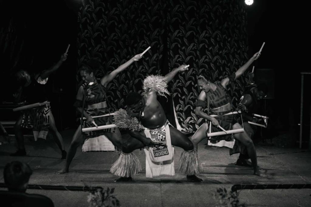 A group of men and woman performing traditional Fijian dance at the Fijian Flying Circus Tour.