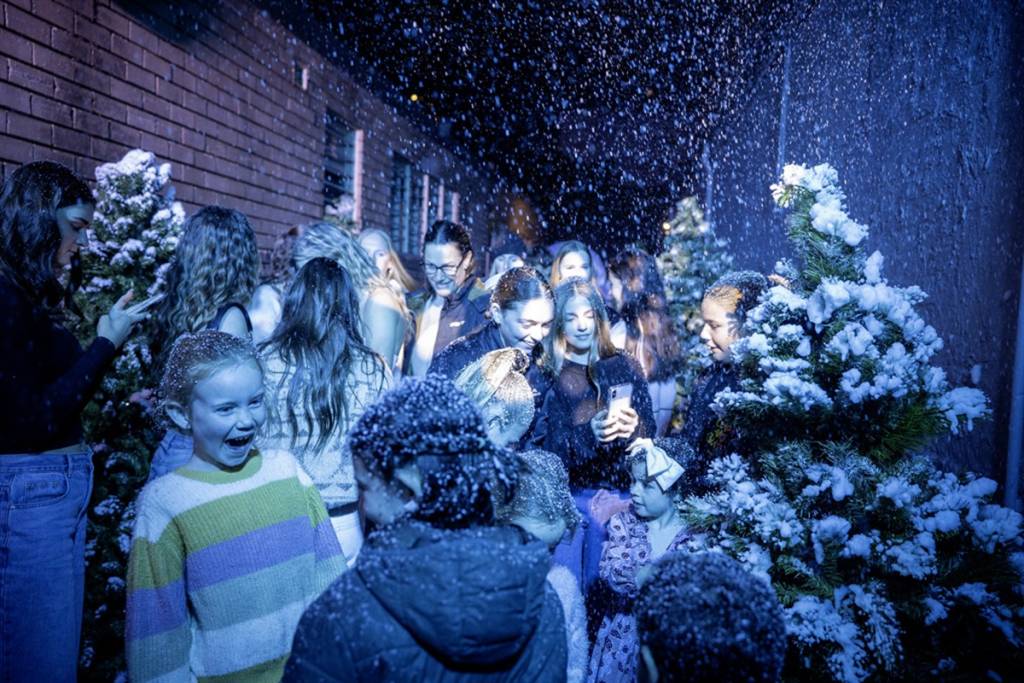 Families enjoy artificial snowfall and winter-themed activities during the Kiama Winter Street Festival in the heart of Kiama